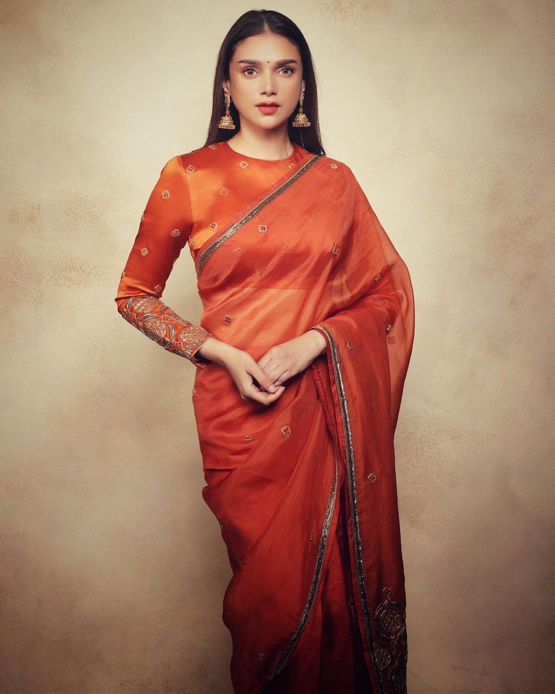 In this look, Aditi wore a stunning sheer orange saree with intricate minimal work on it. The plain saree with a stunning thin border enhanced her look